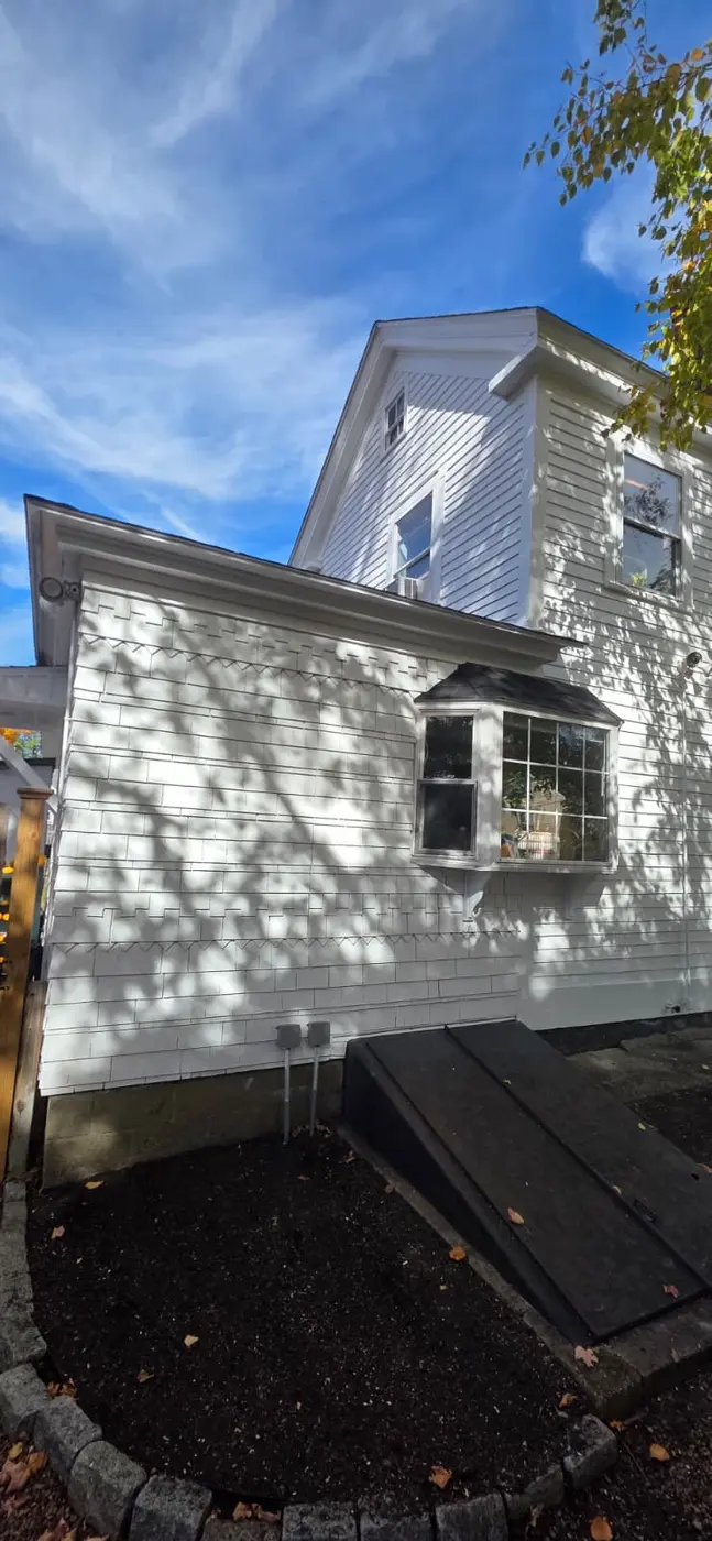 Bay window with fresh white trim on repainted siding